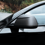 Side view of Tesla model Y Juniper with Carbon Fiber Mirror Caps installed - matte finish