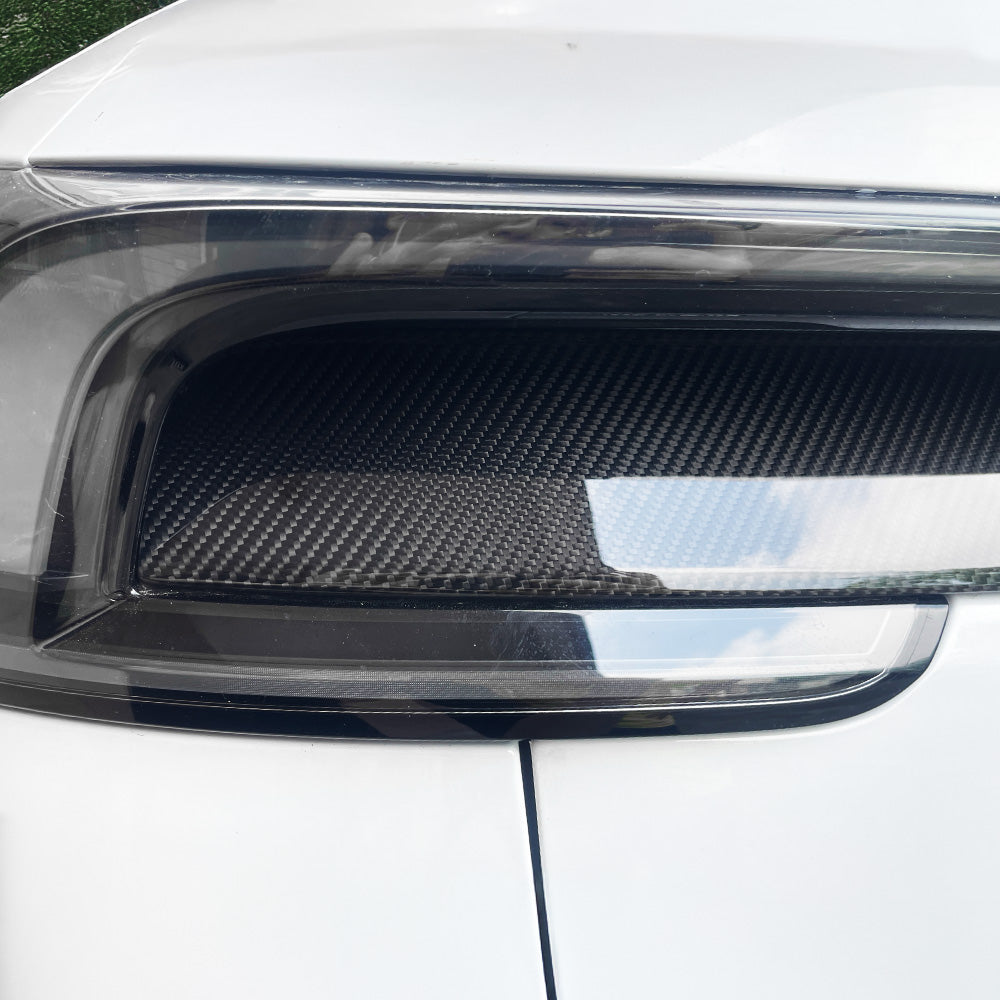 Detailed shot of glossy carbon fiber finish on Tesla Model Y Juniper taillight overlay