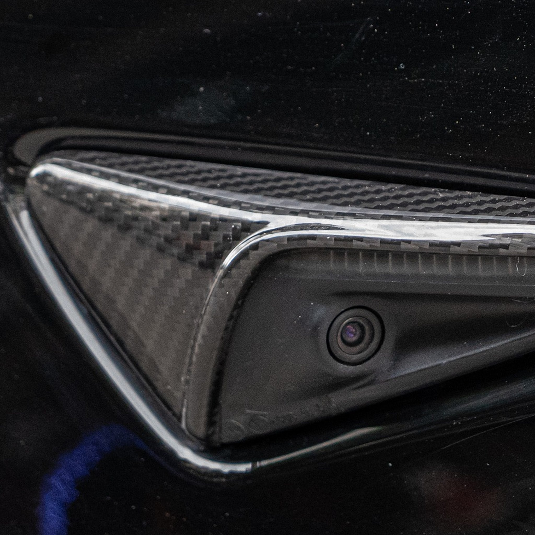 close up detail of model Y carbon fiber side camera cover