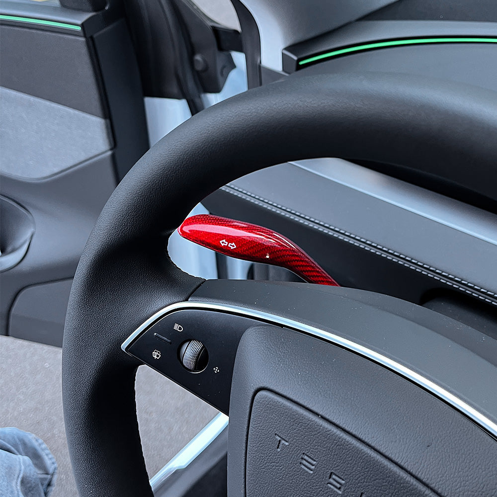 side view of Red glossy Carbon Fiber Turn Signal Stalk Covers installed on Tesla Model Y Juniper