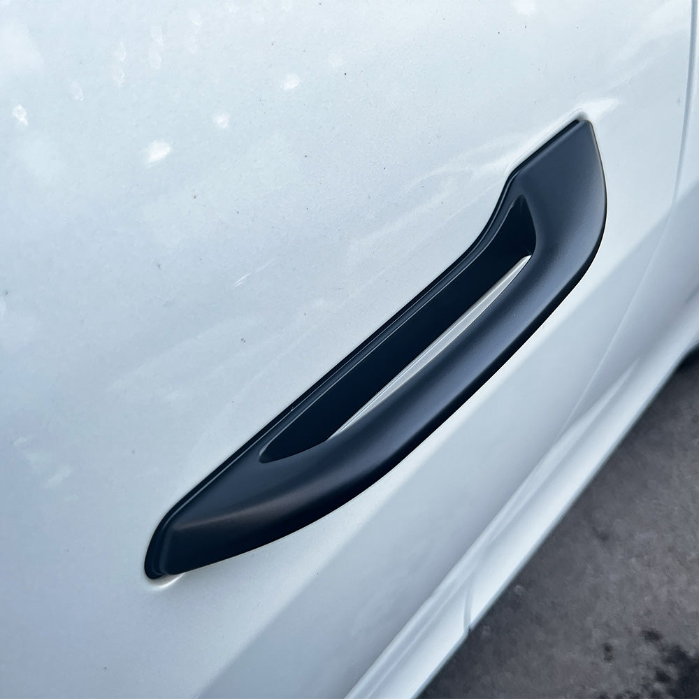 A view of black door handle add-on parts installed on a Tesla Model Y