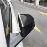 close-up detail shot of Tesla model Y Juniper with Carbon Fiber Mirror Caps installed - glossy finish